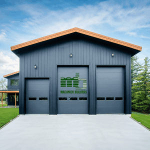 Modern cold-formed steel building with dark vertical metal siding, three overhead garage doors, wood-tone roof trim, and a clean concrete driveway, showcasing a durable commercial construction design